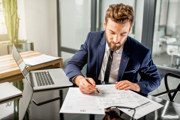 accountant audit and advisory photo via man working on desk